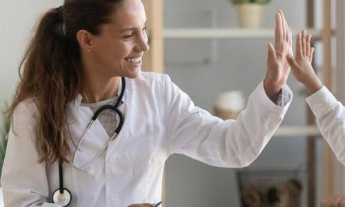 Family nurse practitioner high fiving pediatric patient