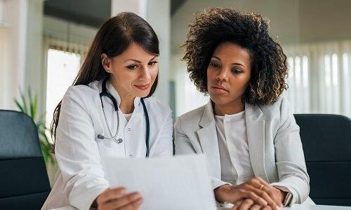 Nurse administrator reviewing patient data with physician